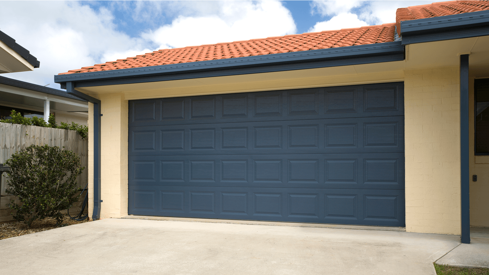 Blue garage door with red-tiled roof